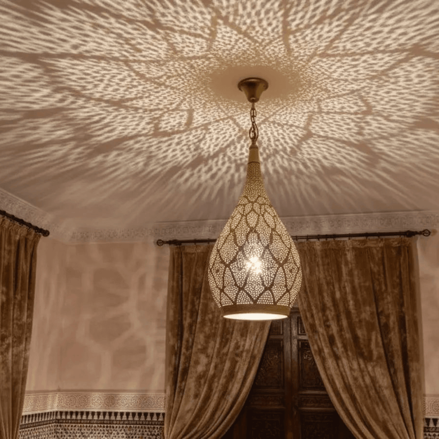 Brass teardrop pendant light with pierced pattern hanging over living room – Brass For Homes