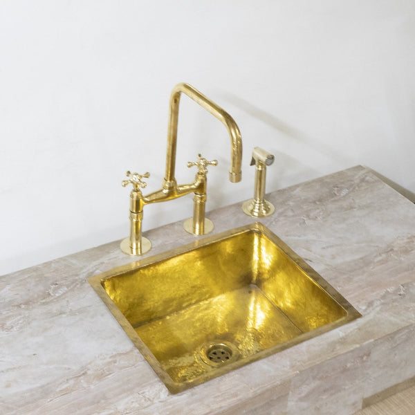 Unlacquered brass bridge kitchen faucet with hand sprayer – front view
