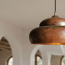 Rustic copper dome ceiling light above wooden farmhouse dining table — Brass For Homes