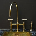 Unlacquered brass bridge faucet lever handles – installed in kitchen